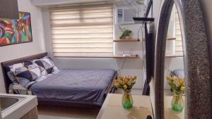um pequeno quarto com uma cama e uma janela em JJMC PLACE 22f em Manila