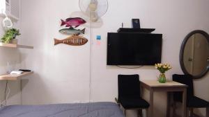 um quarto com uma televisão, uma cama e uma cadeira em JJMC PLACE 22f em Manila
