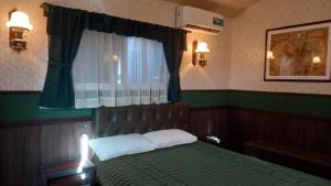 Un dormitorio con una cama verde y una ventana en Tren Del Desierto en Villa Unión
