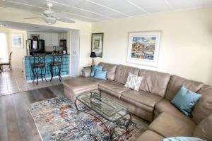 sala de estar con sofá y mesa en Port O' Call C302 - IOP Island Retreat! Treetop Oceanview!, en Isle of Palms