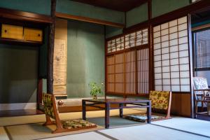a room with a table and two chairs at 金沢町家ゲストハウスかるた in Kanazawa