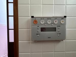 a silver microwave on a wall in a bathroom at Oku Cottage - walk to Ohama Beach - Max 4 ppl in Shimoda