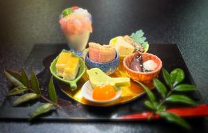 un plato de comida con fruta y una bebida en 割烹旅館霞ヶ浦, en Itako