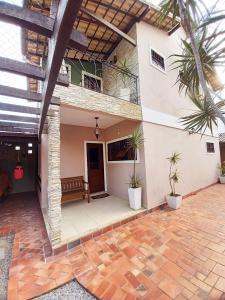 a patio of a house with palm trees at Linda Casa no Jardim Mariléa com Área Gourmet e Hidromassagem! in Rio das Ostras