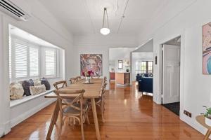 a dining room and living room with a table and chairs at Charming 5BR Family Home w/Pool 10min from Airport in Brisbane