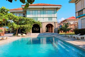 a swimming pool in front of a building at Las Casas Filipinas de Acuzar in Bagac
