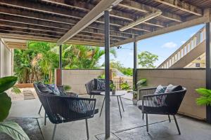 an outdoor patio with chairs and a table at Charming 5BR Family Home w/Pool 10min from Airport in Brisbane