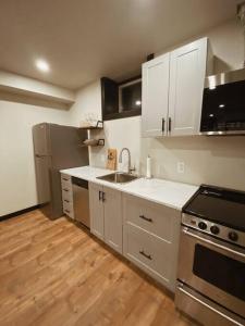 una cocina con armarios blancos y electrodomésticos de acero inoxidable en 1-bedroom apartment in Uptown Waterloo en Waterloo