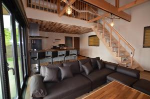 uma sala de estar com um sofá e uma escada em 千葉地域ランキング1位獲得の贅沢な貸別荘全4棟 