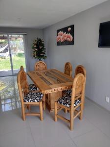 mesa de comedor de madera con sillas y TV en Casas Real Imperio Blue, en Xochitepec