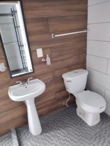 y baño con aseo, lavabo y espejo. en Casas Real Imperio Blue, en Xochitepec