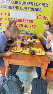 un grupo de personas sentadas alrededor de una mesa con comida en Sun Hà Giang Hotel en Ha Giang