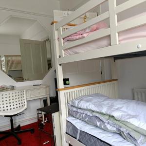 1 dormitorio con litera y escritorio en King-size room in house en Londres