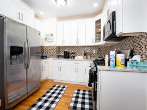 una cucina con armadi bianchi e frigorifero in acciaio inossidabile di A slice of paradise awaits you! a Brooklyn Altre 2 foto