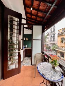 Un balcón con una mesa y sillas y una ventana. en Warm Hanoi, near Hoankiem Lake, 2Brs, Old Quarter, en Hanói