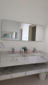 un bagno con due lavandini e un grande specchio di استراحة الضيافة ad Al Jubail