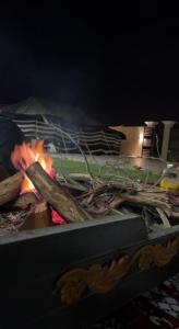 a person holding a spatula over a fire at استراحة الضيافة in Al Jubail