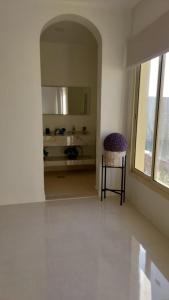 um quarto branco com uma cadeira e um espelho em استراحة الضيافة em Al Jubail
