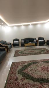 a living room with couches and a rug at استراحة الضيافة in Al Jubail