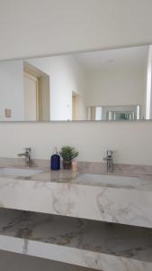 ein Badezimmer mit 3 Waschbecken und einem großen Spiegel in der Unterkunft استراحة الضيافة in Al-Dschubail