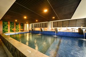a swimming pool in a building with a pool at Nata Azana Hotel Solo in Solo