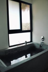 y baño con bañera y ventana. en Casa Luni, en Puerto Escondido