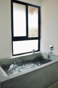 Cette chambre dispose d'une baignoire et d'une fenêtre. dans l'établissement Casa Luni, à Puerto Escondido