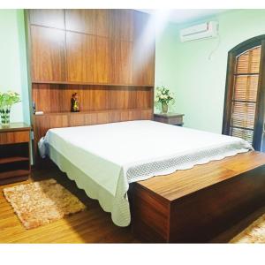 1 dormitorio con 1 cama grande y cabecero de madera en Recanto do Sossego, en Presidente Prudente