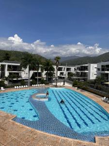 a large swimming pool with people in the water at Apartasol Santafe de Antioquia 15 in Santa Fe de Antioquia