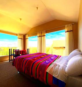 a bedroom with a bed and a large window at Uros Maya Lodge in Puno