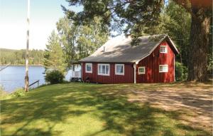 uma casa vermelha sentada ao lado de um lago em Amazing Home In Rottneros With Kitchen em Bråsstorp