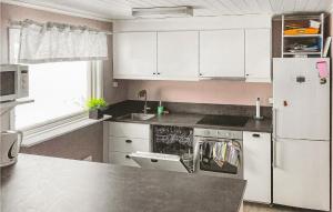 uma cozinha com armários brancos e um frigorífico branco em Amazing Home In Rottneros With Kitchen em Bråsstorp