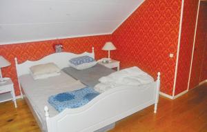 a white bed in a bedroom with red walls at Stunning Home In Rottneros With 3 Bedrooms And Wifi in Bråsstorp