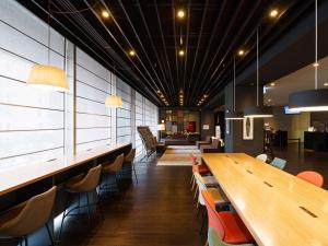 a cafeteria with a long wooden table and chairs at Hiroshima Washington Hotel in Hiroshima