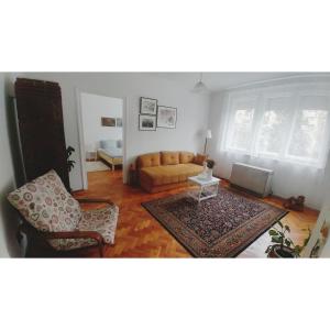 ein Wohnzimmer mit einem Sofa und einem Stuhl in der Unterkunft Kennedy apartment in Tošin Bunar