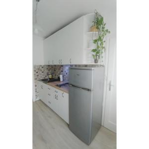 eine Küche mit weißen Schränken und einem Waschbecken in der Unterkunft Kennedy apartment in Tošin Bunar