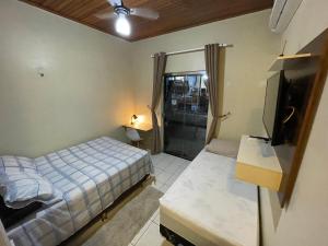 Un pequeño dormitorio con una cama y un televisor. en Smart Suíte, en Boa Vista