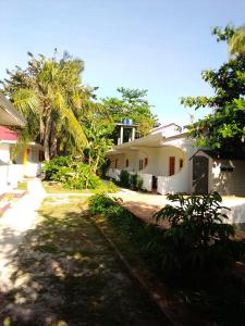 una casa con palmeras delante en Mr.kwiiz inn, en Daanbantayan