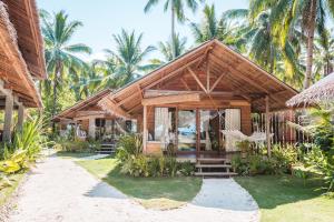 un complexe avec un bâtiment planté de palmiers dans l'établissement Soultribe Beach Retreat, à General Luna