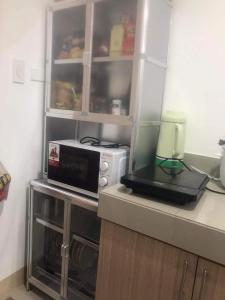 un forno a microonde seduto su un bancone in cucina di Watanabe Condo Unit a Pasong Bayog