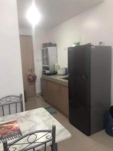 uma cozinha com um frigorífico preto e uma mesa em Watanabe Condo Unit em Pasong Bayog