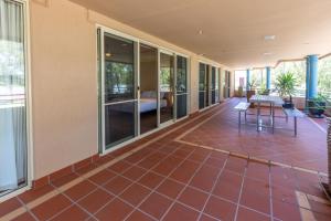 a room with a red tile floor and windows at Apartment 2, 9 River Lane Mannum in Mannum