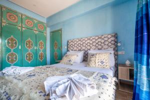 ein Schlafzimmer mit einem großen Bett mit blauen Wänden in der Unterkunft Riad Les Nuits De Fès in Fès