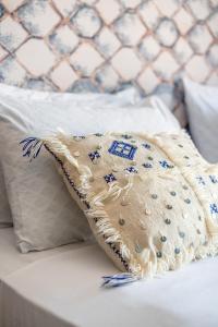 a blanket sitting on a bed next to a pillow at Riad Les Nuits De Fès in Fez