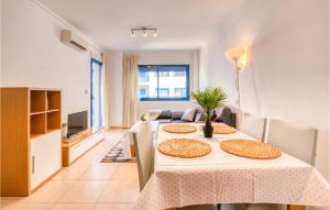 Stunning Apartment In Alicante With Outdoor Swimming Pool في أليكانتي: غرفة طعام مع طاولة وغرفة معيشة
