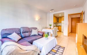sala de estar con sofá púrpura y mesa en Stunning Apartment In Alicante With Outdoor Swimming Pool, en Alicante