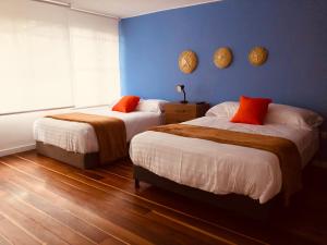 - 2 lits dans une chambre aux murs bleus dans l'établissement CASA CREAZZO 62 - Movistar Arena, à Bogotá