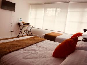a hotel room with two beds and a window at CASA CREAZZO 62 - Movistar Arena, Vive Claro in Bogotá