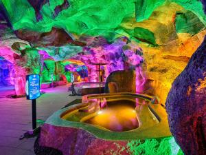 a bath tub in a cave with colorful lights at Regal Palace DeRUCCI Resort in Huizhou