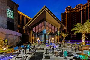 a group of tables and chairs in front of a building at Regal Palace DeRUCCI Resort in Huizhou